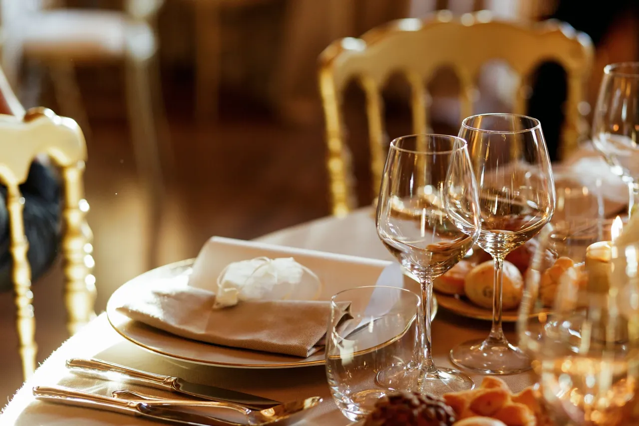 Gala table with gold chairs, candlelight and wine glasses set for dinner
