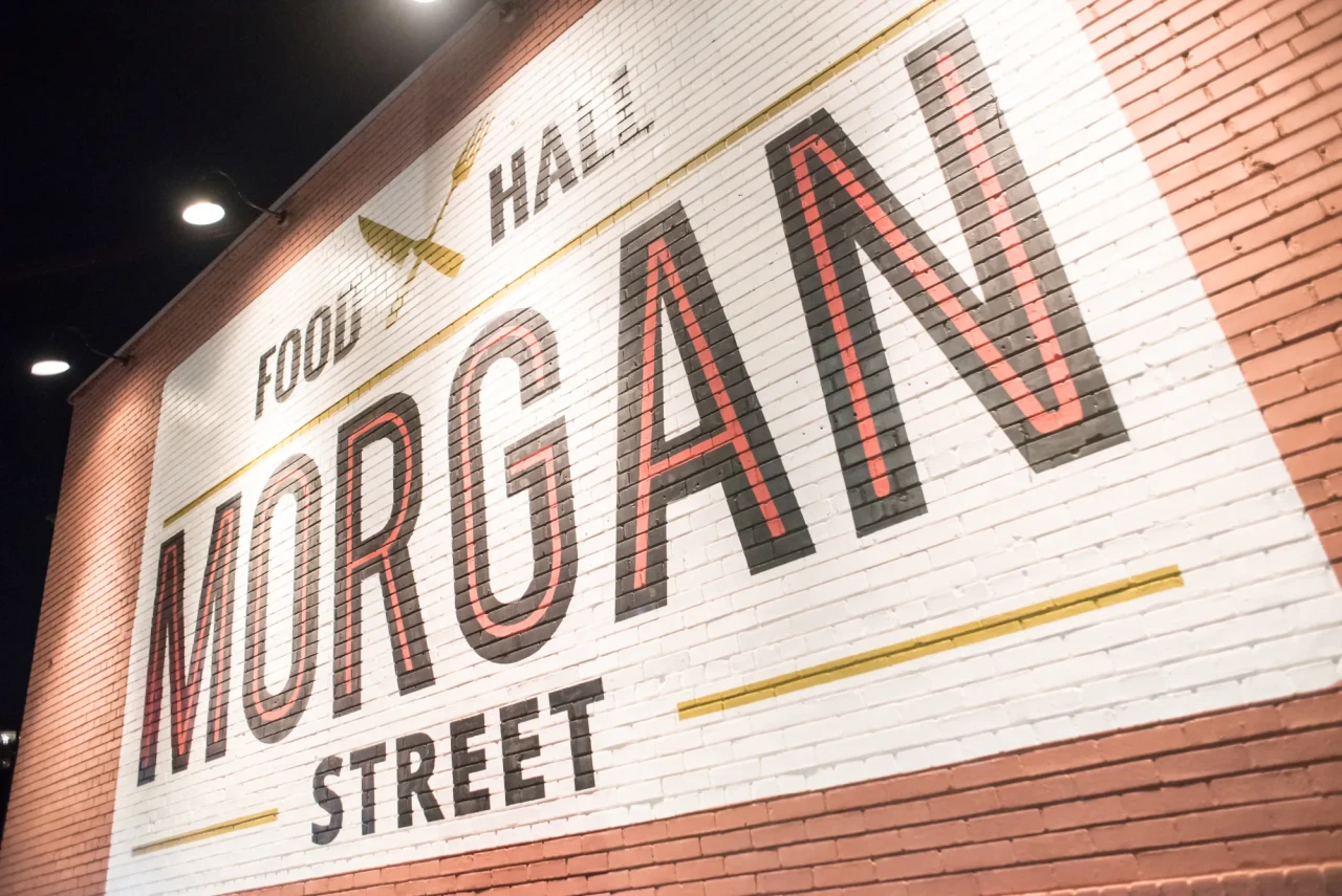 Morgan Street Food Hall sign painted on a white brick wall at night