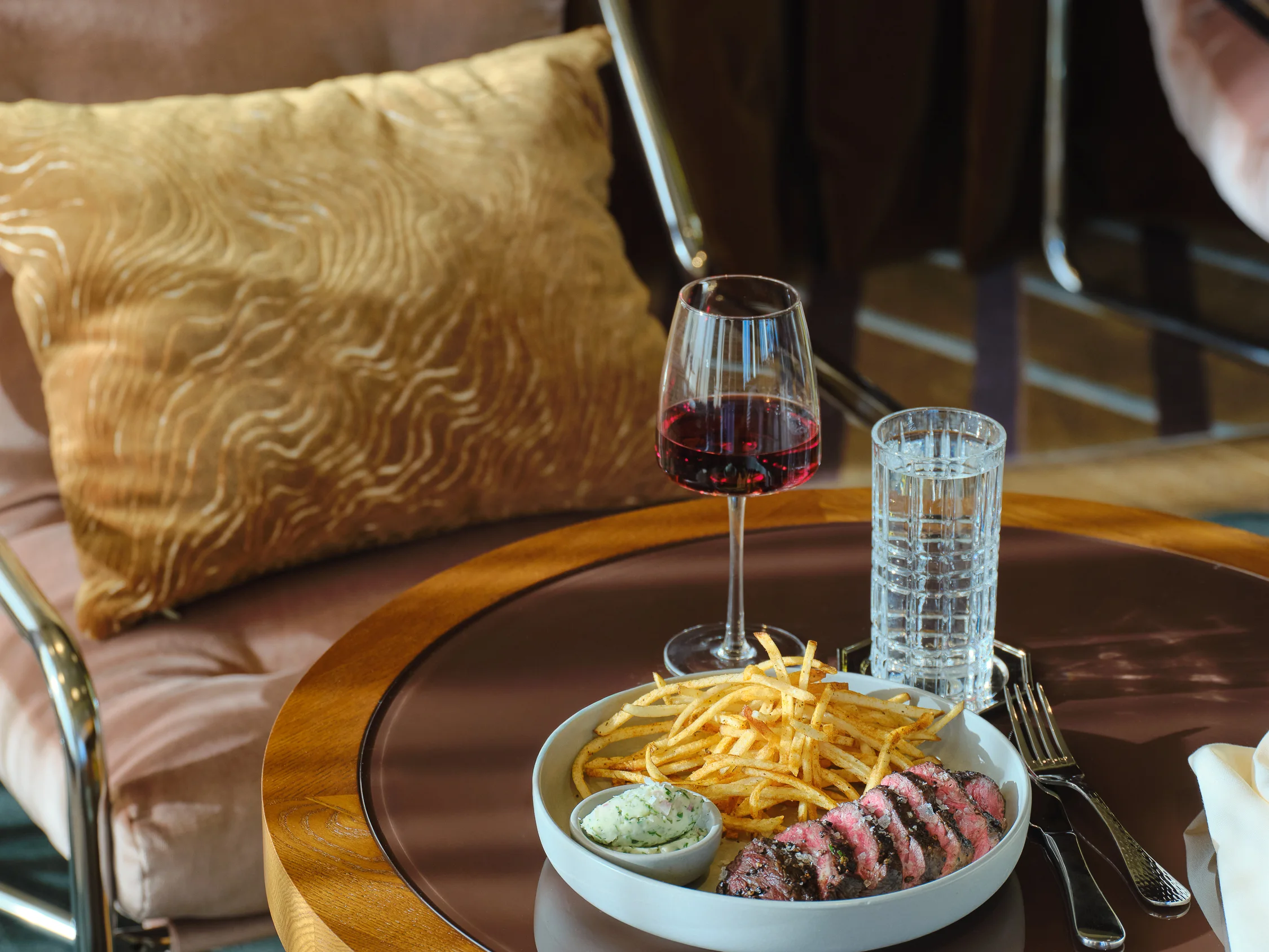 Grilled hangar steak with frites and a glass of red wine, served in the lounge at High Ground