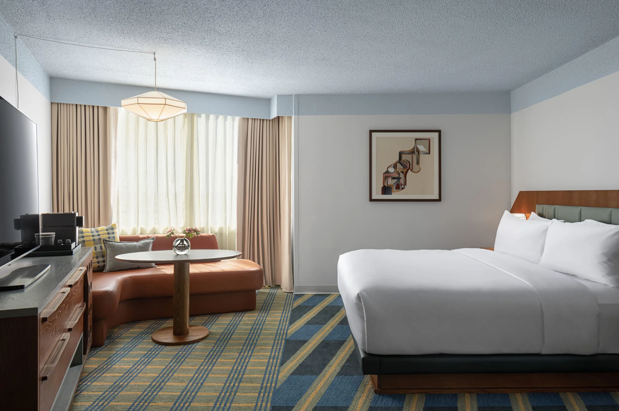 King guest room at Hotel Indigo Raleigh Downtown with mid-century furnishings and skyline views